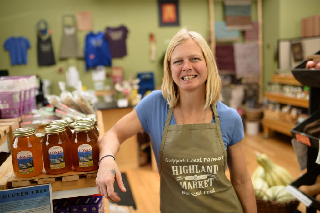 Local Food Market Manager next to shelves with local honey