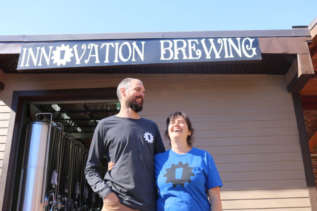 Brewery business owners a married couple in front of business sign