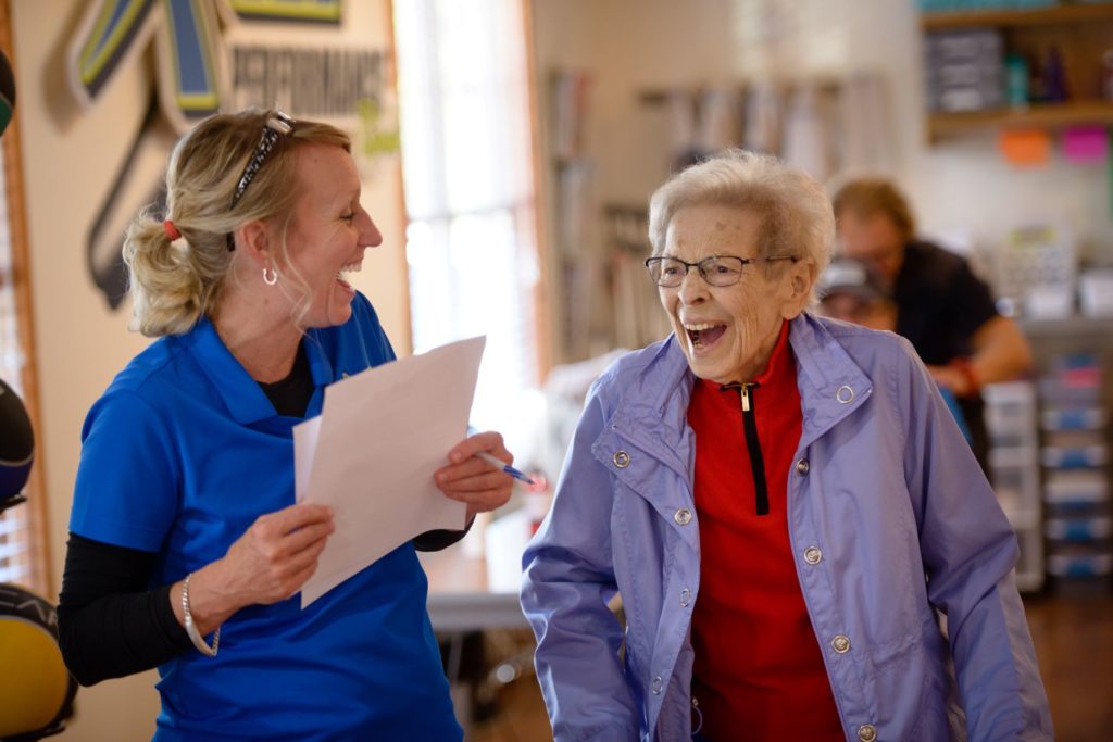 Physical therapy business owner laughing with client