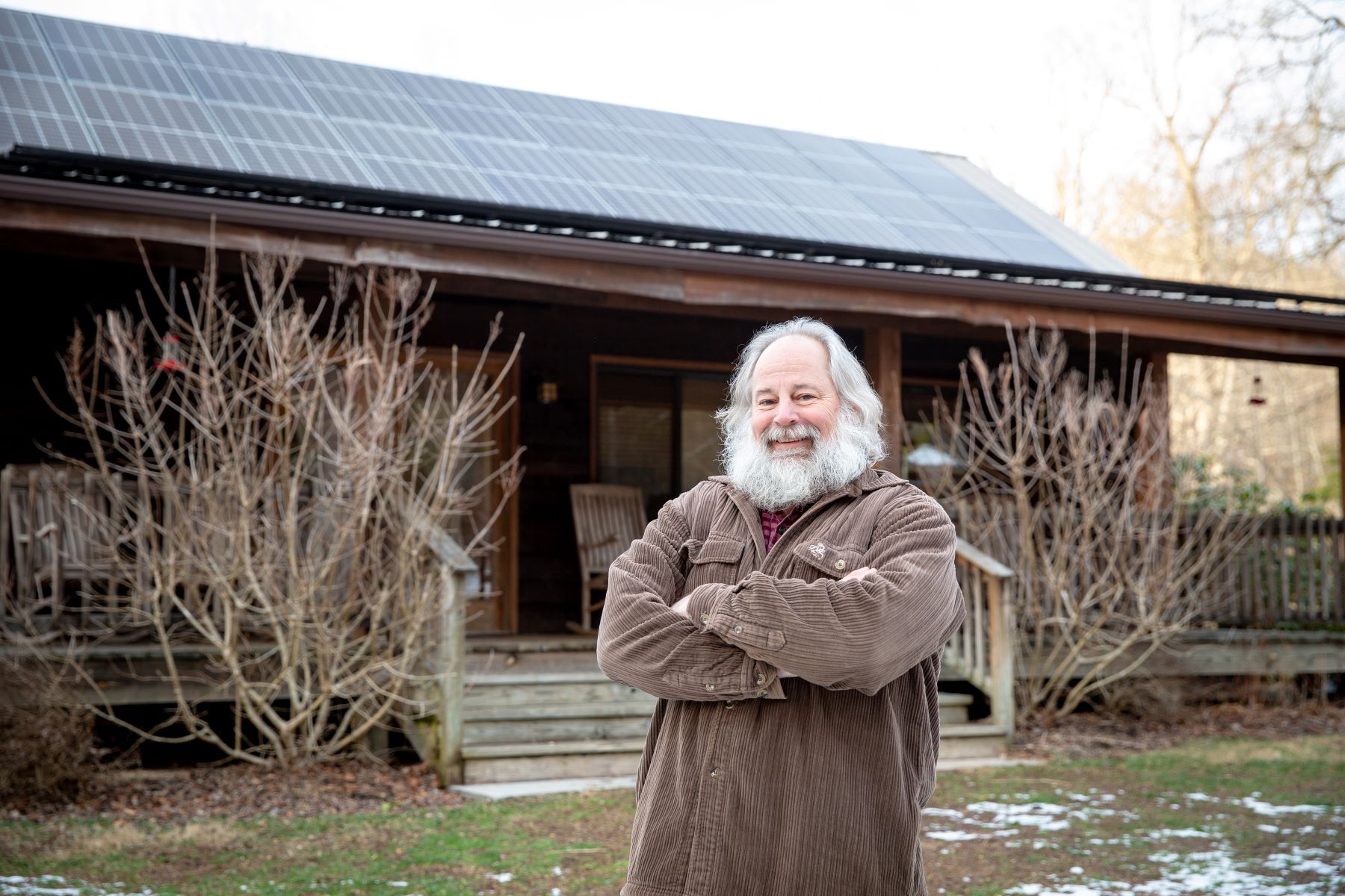 Borrower standing in front of his cabin rental business, with solar on the roof