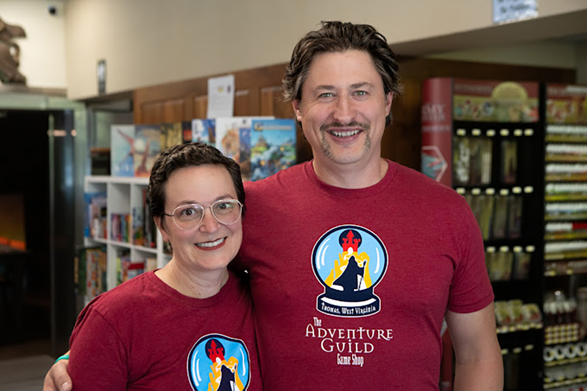 Jason and Angie, owners of the Adventure Guild, smiling in their building.