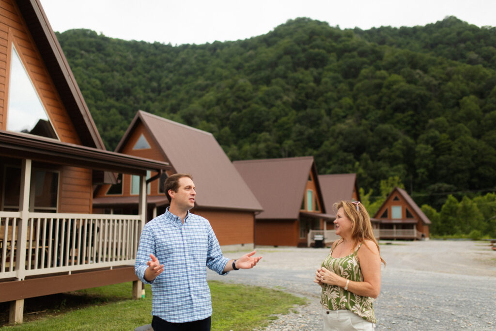 People talking outside of a-frame cabins, part of Appalachian Outpost.